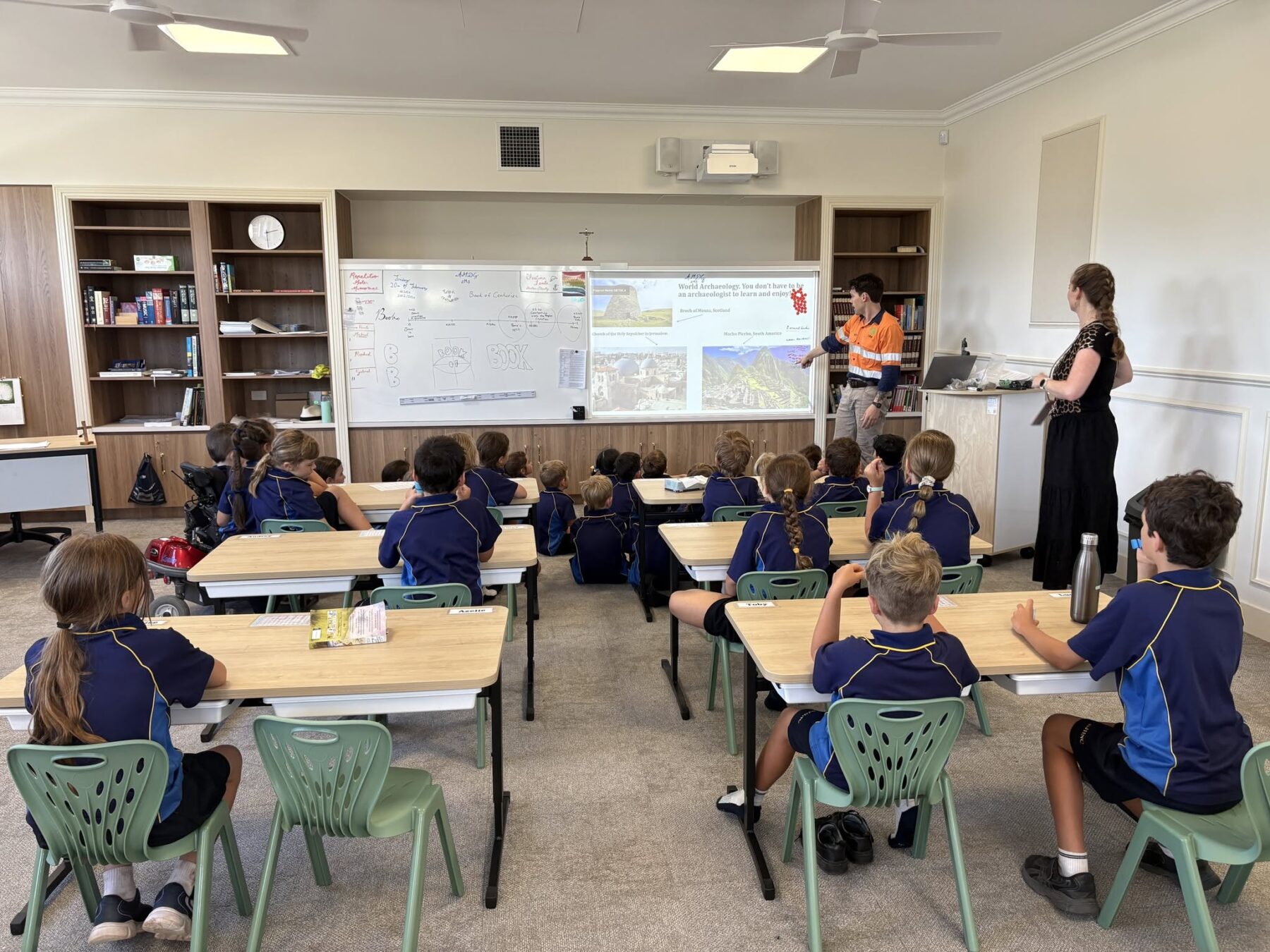 St John Henry Newman College Tarragindi Students in class at St John Henry Newman College Tarragindi, a new classical Catholic school on Brisbane's southside.
Primary school students seated at desks in a classroom, listening to a teacher at the whiteboard at St John Henry Newman College